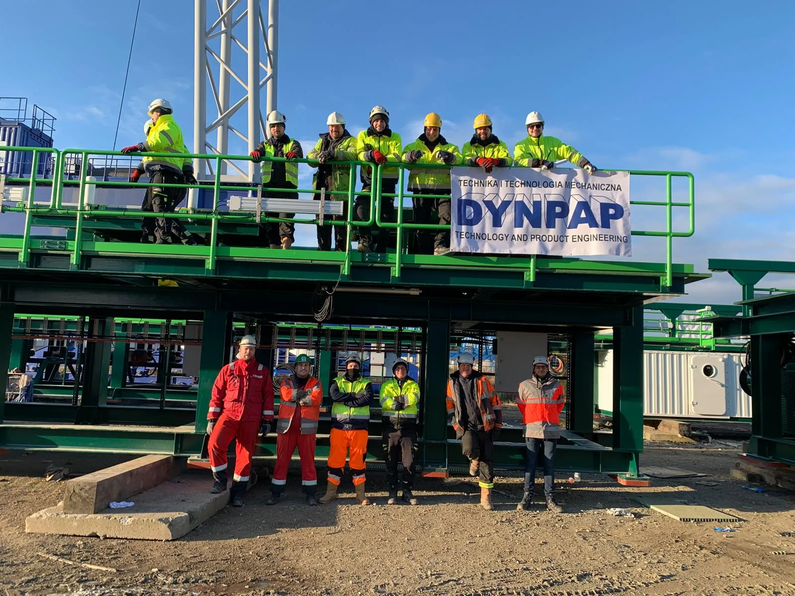 Grupa pracowników DYNPAP, pierwsza część stoi na wyprodukowanej przez nich zielonej platformie, druga część znajduje się pod platformą